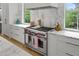 Modern kitchen with stainless steel Wolf range, marble backsplash, and white cabinetry at 1433 Wessyngton Ne Rd, Atlanta, GA 30306