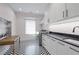 Modern laundry room with stylish chevron flooring, white cabinetry, and stainless steel appliances at 1433 Wessyngton Ne Rd, Atlanta, GA 30306