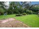 Spacious backyard with a large grassy area, a swing set, and mature trees at 1472 High Meadow Dr, Stone Mountain, GA 30083