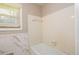 Bright bathroom featuring tiled walls, a bathtub, and a window for natural light at 1472 High Meadow Dr, Stone Mountain, GA 30083
