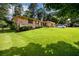 Ranch-style home featuring a well-manicured lawn, classic brick facade, shutters, and a car parked in the driveway at 1472 High Meadow Dr, Stone Mountain, GA 30083