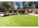 Charming brick ranch with a well-maintained front lawn, shrubs, and a paved driveway at 1472 High Meadow Dr, Stone Mountain, GA 30083