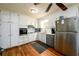 Bright kitchen featuring stainless steel appliances, white cabinets, and wood flooring at 1472 High Meadow Dr, Stone Mountain, GA 30083