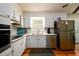 Well-lit kitchen with white cabinetry, stainless steel appliances, and tiled backsplash at 1472 High Meadow Dr, Stone Mountain, GA 30083