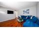 Cozy living room with modern decor, a large blue sectional, and dark wood flooring at 1472 High Meadow Dr, Stone Mountain, GA 30083