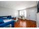 Bright living room featuring wood floors, a blue sectional sofa, and a glass coffee table at 1472 High Meadow Dr, Stone Mountain, GA 30083