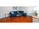 Bright living room showcasing a blue sectional sofa, glass tables and hardwood floors at 1472 High Meadow Dr, Stone Mountain, GA 30083