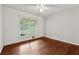 Bright bedroom with hardwood floors, a ceiling fan, and ample natural light from the large window at 1913 Ferry Dr, Marietta, GA 30066