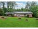 Charming brick home with a spacious front yard and mature trees offers classic curb appeal at 1913 Ferry Dr, Marietta, GA 30066