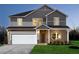 Two-story home featuring a two-car garage, brick facade, manicured lawn, and welcoming entryway at 1921 Fairchild Ln, Grayson, GA 30017