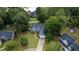 Aerial view shows a charming blue home nestled among mature trees in a Gathering-friendly neighborhood at 556 Walton Dr, Social Circle, GA 30025
