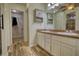 Bathroom with a double sink vanity, wood-look tile, and access to a walk-in closet at 556 Walton Dr, Social Circle, GA 30025
