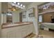 Bathroom showcasing a double sink vanity, wood-look tile, and bedroom access at 556 Walton Dr, Social Circle, GA 30025