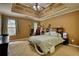 Primary bedroom featuring a tray ceiling, ceiling fan, and plush carpet at 556 Walton Dr, Social Circle, GA 30025
