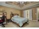 Relaxing bedroom featuring a tray ceiling, large bed, and ensuite bath access at 556 Walton Dr, Social Circle, GA 30025