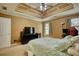 Bedroom showcases a tray ceiling, ceiling fan, and a comfortable bed at 556 Walton Dr, Social Circle, GA 30025