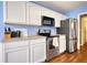Functional kitchen featuring modern appliances, white cabinetry, and ample counter space at 556 Walton Dr, Social Circle, GA 30025