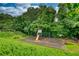 Fenced-in community playground featuring a slide, swings, picnic tables, benches, and a wooded backdrop at 556 Walton Dr, Social Circle, GA 30025