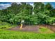 Community playground with a slide, swings, picnic tables, and a fenced-in area surrounded by trees at 556 Walton Dr, Social Circle, GA 30025