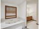Bathroom features a jetted tub beneath a wood-trimmed window and a view of a vanity with a mirror at 2110 Waterloo Cir, Lawrenceville, GA 30043