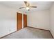 Carpeted bedroom with a ceiling fan and two wood-paneled closet doors at 2110 Waterloo Cir, Lawrenceville, GA 30043