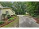 A long driveway leads to a charming home surrounded by lush greenery and tall trees at 2110 Waterloo Cir, Lawrenceville, GA 30043