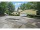 Charming yellow home with large driveway, lush landscaping, and attached garage, offering curb appeal at 2110 Waterloo Cir, Lawrenceville, GA 30043