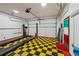 A spacious garage with car lift, checkerboard flooring, and ample space for parking and projects at 2110 Waterloo Cir, Lawrenceville, GA 30043