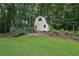 Quaint storage shed in the backyard surrounded by lush greenery and mature trees providing extra storage at 2110 Waterloo Cir, Lawrenceville, GA 30043