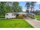 Charming ranch home showcasing a well-manicured lawn, carport, and inviting covered front porch at 2432 Kelly Lake Dr, Decatur, GA 30032