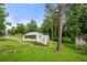 View of the exterior highlighting a spacious lawn, mature trees, and an attached carport at 2432 Kelly Lake Dr, Decatur, GA 30032