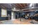 Unfinished basement with black painted walls, exposed ceiling ductwork, and access to the outside at 265 Forest Lake Dr, Covington, GA 30016