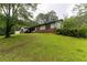 Exterior view of home on a hill, showcasing a large lawn and brick accents at 265 Forest Lake Dr, Covington, GA 30016