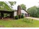 Side view of the home, featuring the two-car garage, chimney, and covered area at 265 Forest Lake Dr, Covington, GA 30016