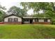 Charming single-story home with brick facade, well-manicured lawn, and mature trees at 265 Forest Lake Dr, Covington, GA 30016