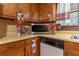 Kitchen area with wooden cabinets, laminate countertops, a microwave, and a dishwasher at 265 Forest Lake Dr, Covington, GA 30016