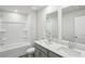 A bright bathroom features double sinks, and a shower and tub combination with white tile at 386 Tallulah Ln, Grayson, GA 30017