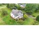 Aerial view of a beautiful brick and white home with a large yard, a deck, and mature trees at 3992 Spot Rd, Cumming, GA 30040