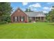 Charming brick home with well-maintained landscaping, a green lawn, and a welcoming front porch at 3992 Spot Rd, Cumming, GA 30040