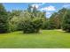 Lush green yard featuring mature trees, creating a private and serene setting for the property at 3992 Spot Rd, Cumming, GA 30040