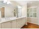 Bright bathroom with double sinks, large mirror, and walk-in closet access at 5114 N Ivy Ne Rd, Atlanta, GA 30342