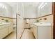 Bathroom with double vanity, large mirrors, and tan tiled walls and floors at 5114 N Ivy Ne Rd, Atlanta, GA 30342