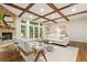 Cozy living room featuring a stone fireplace, coffered ceilings, and plenty of natural light at 5114 N Ivy Ne Rd, Atlanta, GA 30342