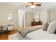 Neutral-toned main bedroom with ceiling fan, decor, wood floors, and access to ensuite at 5114 N Ivy Ne Rd, Atlanta, GA 30342