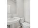 Clean bathroom with a pedestal sink, mirror, and efficient toilet at 1539 High Falls Ln, Grayson, GA 30017