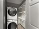 This laundry area features a stackable washer/dryer with shelving units to maximize space at 1902 Memorial Se Dr, Atlanta, GA 30317