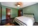 Bedroom with green walls, a metal bed frame, wood floors and a ceiling fan at 3020 Washington Rd, East Point, GA 30344