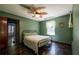 Bedroom with green walls, a metal bed frame, and a unique leaf-shaped ceiling fan at 3020 Washington Rd, East Point, GA 30344