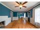 Bright living room with hardwood floors, wainscoting, ceiling fan, and blue accent wall at 3020 Washington Rd, East Point, GA 30344