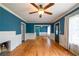 Bright living room with hardwood floors, wainscoting, ceiling fan, and blue accent wall at 3020 Washington Rd, East Point, GA 30344